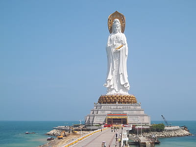 woman statue placed near body of water with bridge thumbnail