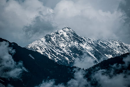 snow-covered mountains under gray cloudy sky during daytime thumbnail