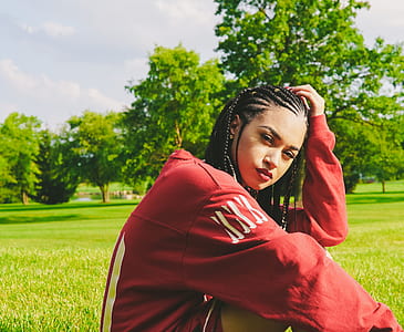 woman sitting on grass surrounded with trees at daytime thumbnail