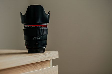 close-up photo of black camera lens on beige wooden cabinet thumbnail