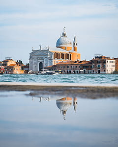 reflective photography of cathedral near body of water thumbnail