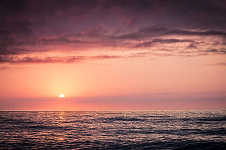 camly body of water under cloudy sky at sunset thumbnail