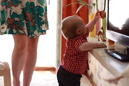 toddler standing in front of flat screen monitor thumbnail
