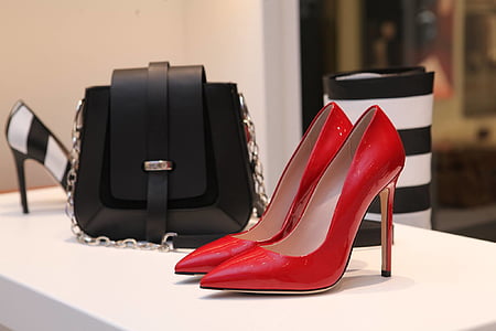 red stiletto pumps, black leather satchel bag on display thumbnail