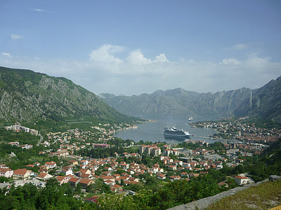 aerial view of houses near body of water and mountains thumbnail