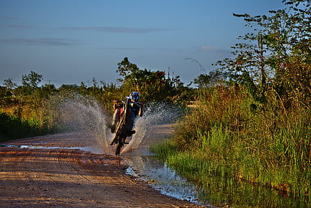 person wearing helmet riding motorcycle on road during daytime thumbnail