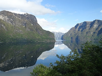 body of water between gray rock mountains at daytime thumbnail