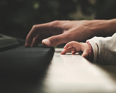person and toddler's hands playing piano thumbnail