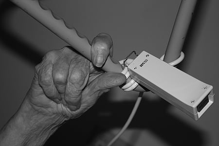 persons hand on gray metal bar thumbnail