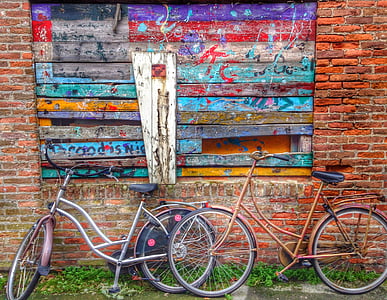 two brown and gray cruiser bikes on brown wall thumbnail