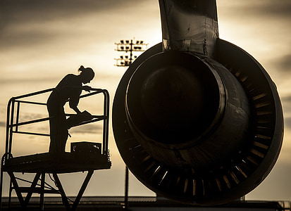 silhouette of person checking on airplane jet engines thumbnail