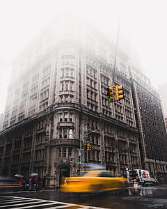 brown concrete building covered by white clouds thumbnail