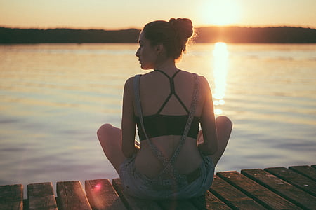 woman sitting on brown wooden docking boat thumbnail