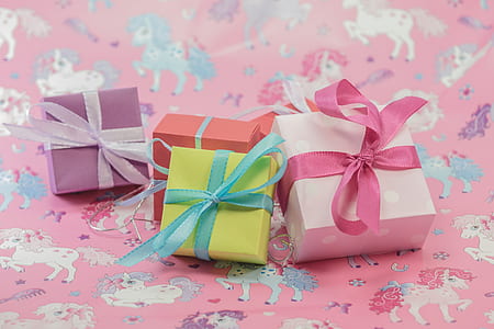 several assorted-color boxes on top of pink textile thumbnail
