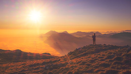 silhouette of person standing on mountain during golden hour thumbnail