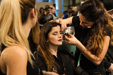 close-up photography of woman putting mascara on woman's eyelashes thumbnail