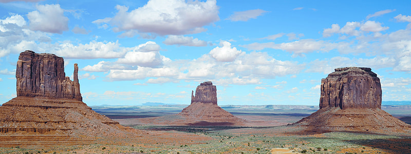 brown rock formations under cloudy blue sky during daytime thumbnail