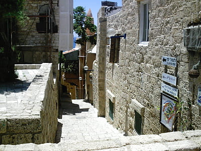 empty gray stone pathway in the middle of stone buildings during day thumbnail