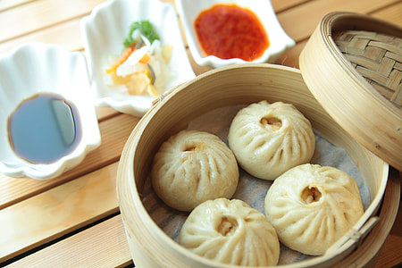 steamed buns with three bowls of assorted sauces thumbnail