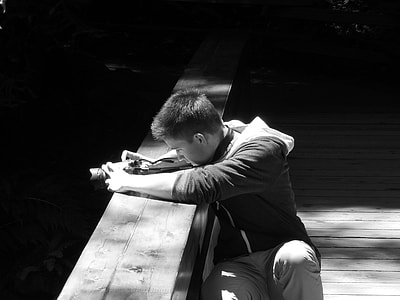 grayscale photo of man taking photograph on bridge thumbnail