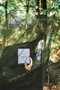 person on hammock holding tablet computer thumbnail