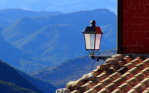 black lamppost on roof with mountains background thumbnail