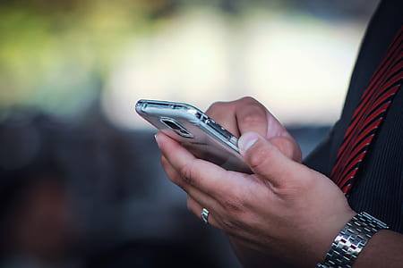 selective focus photography of person holding smartphone thumbnail