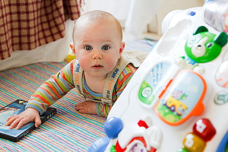 baby lying on ground infront of activity walker thumbnail
