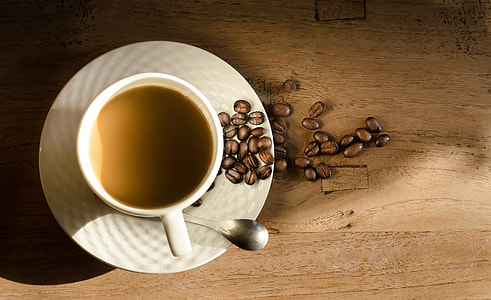 round white ceramic cup with coffee on the top of brown wooden suface thumbnail