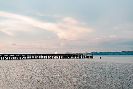 brown wooden dock near mountain at daytime thumbnail