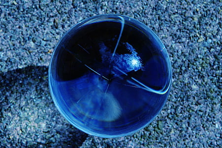 round blue marble on gray concrete pavement thumbnail