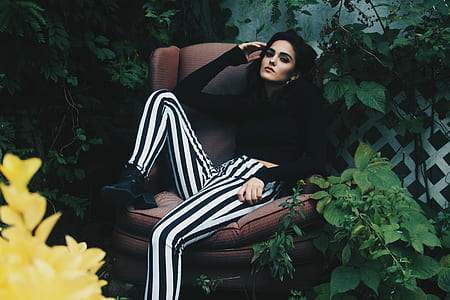 woman sitting on brown fabric winged chair thumbnail