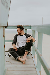 man in white and black long-sleeved shirt and black denim jeans thumbnail