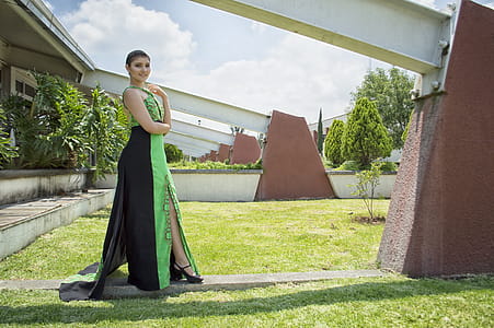 Woman in Green and Black Dress Standing in Front of Wall thumbnail