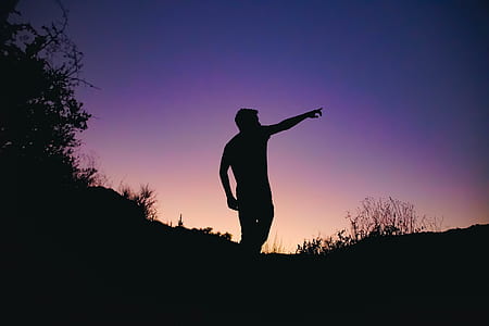 silhouette of man pointing up towards the sky thumbnail