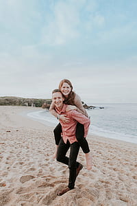 man carrying woman near sea shore thumbnail