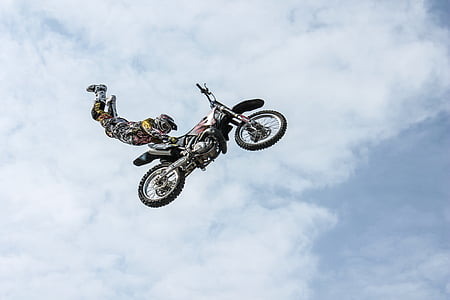 man wearing motocross gear doing superman stunt in mid air thumbnail