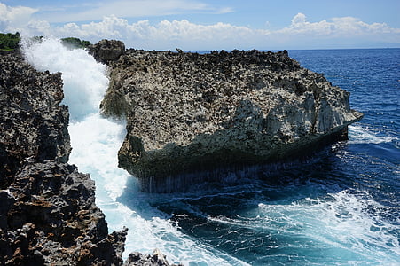 birds eye view of rock formation on body of water thumbnail