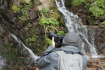 man taking picture of waterfalls thumbnail