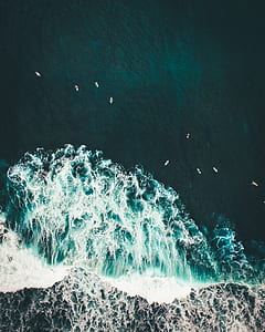 aerial photography of boat on body of water with ocean waves thumbnail