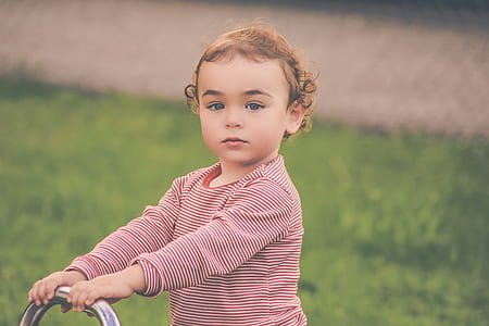 toddler holding on chrome bar in green lawn thumbnail