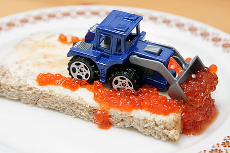 blue and grey skid loader toy on top of cake thumbnail