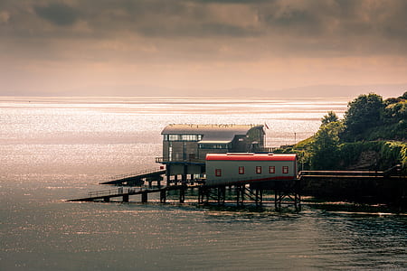 white shed beside body of water thumbnail