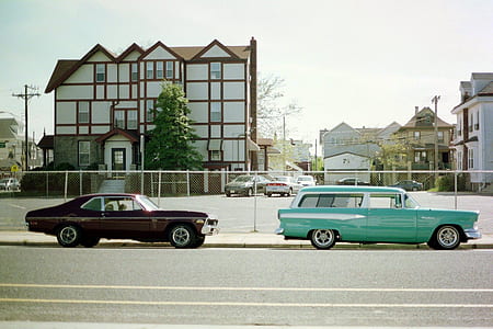 black and teal cars on the side of the street thumbnail