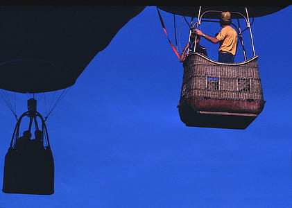 Man Wearing Orange T-shirt Riding on Brown Parachute thumbnail
