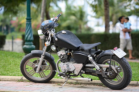 parked black motorcycle on gray pavement thumbnail