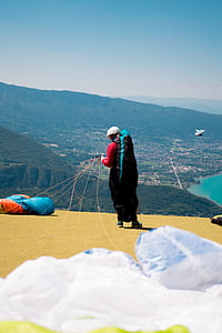 person carrying parachute near town thumbnail