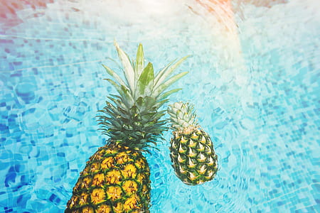 two pineapples on body of water during daytime thumbnail