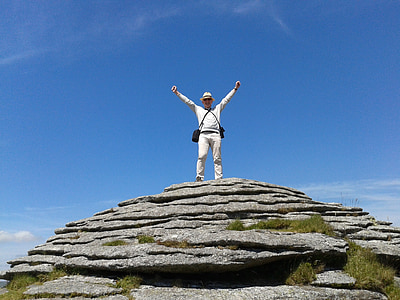 man standing on rock mountain under blue sky thumbnail