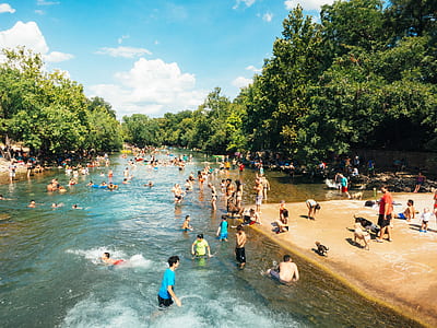 people gathered in body of water surrounded by trees thumbnail